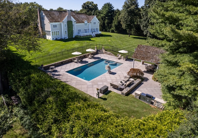 view of pool with a patio and a lawn