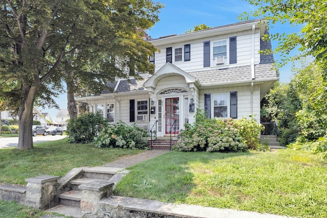 view of front of house with cooling unit and a front lawn