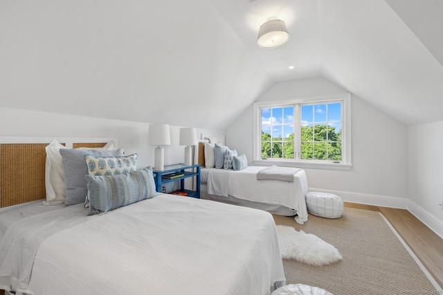 bedroom featuring light wood-type flooring and lofted ceiling