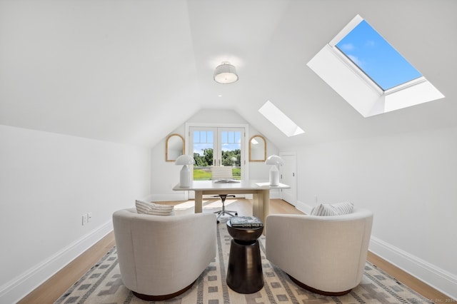 sitting room featuring vaulted ceiling with skylight and light wood-type flooring