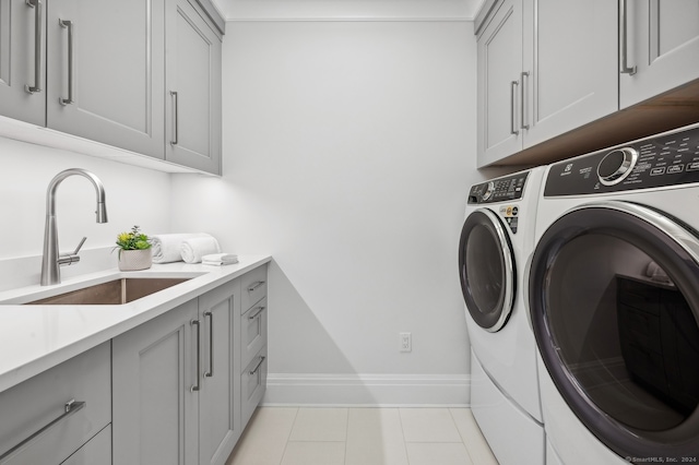 clothes washing area featuring cabinets, light tile patterned floors, independent washer and dryer, and sink