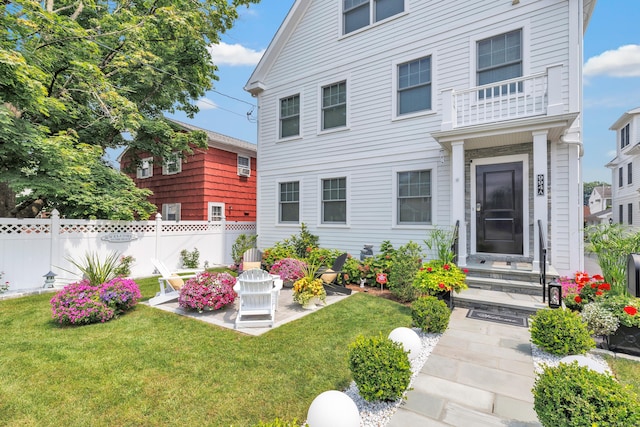 view of front of property featuring fence, a patio, and a front yard