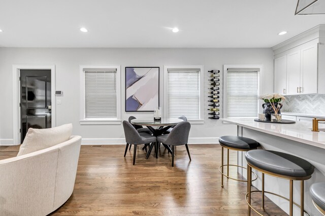 dining room with baseboards, wood finished floors, and recessed lighting