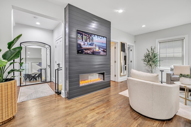 living area featuring light wood finished floors, a fireplace, and recessed lighting