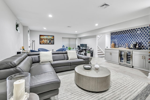 living room with wine cooler, recessed lighting, visible vents, a bar, and stairs