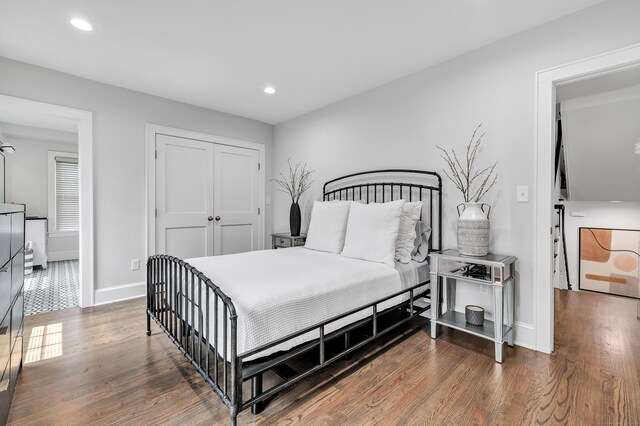 bedroom with a closet, baseboards, wood finished floors, and recessed lighting