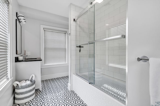 bathroom featuring enclosed tub / shower combo, tile patterned flooring, vanity, and baseboards