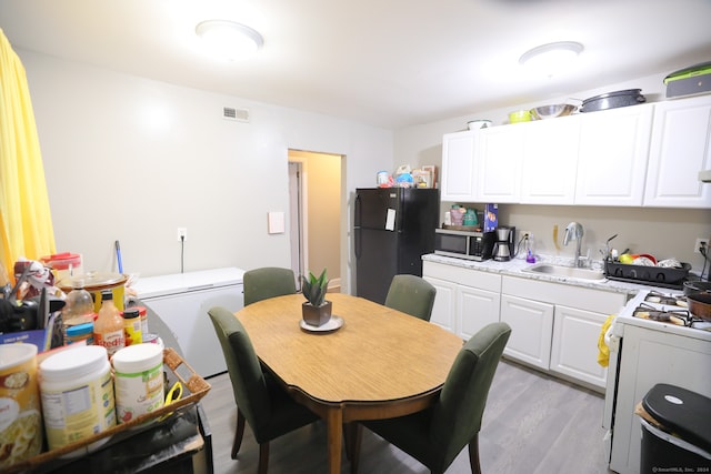 dining space with sink and light wood-type flooring