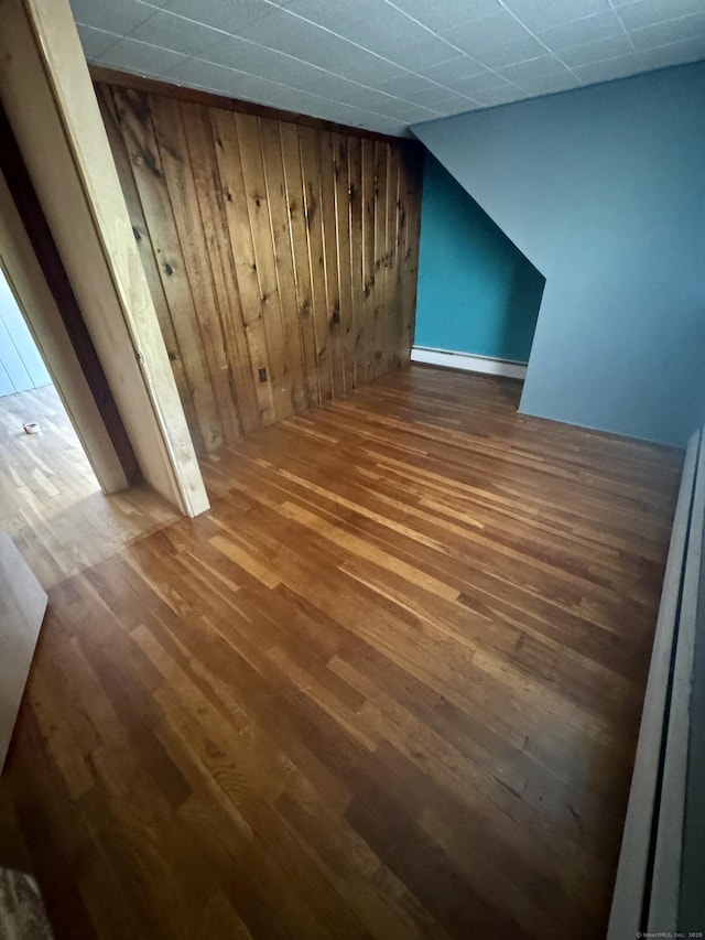 additional living space featuring wood walls and wood finished floors