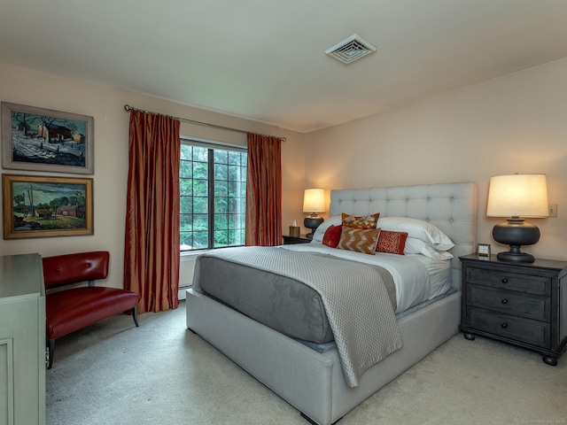 bedroom featuring baseboard heating and light carpet