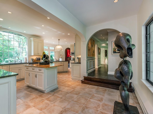 kitchen featuring hanging light fixtures, a kitchen island, and cream cabinetry