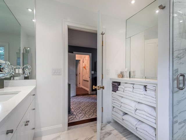 bathroom featuring vanity and a shower with door