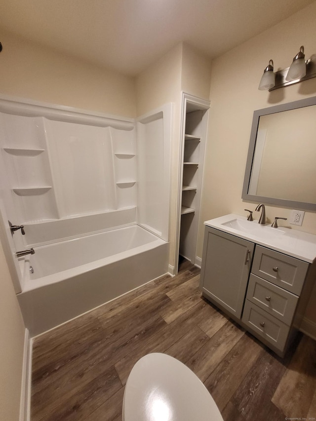 bathroom featuring shower / bathtub combination, hardwood / wood-style floors, and vanity