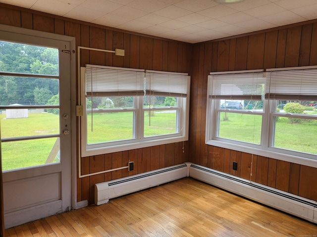 unfurnished sunroom with a baseboard heating unit