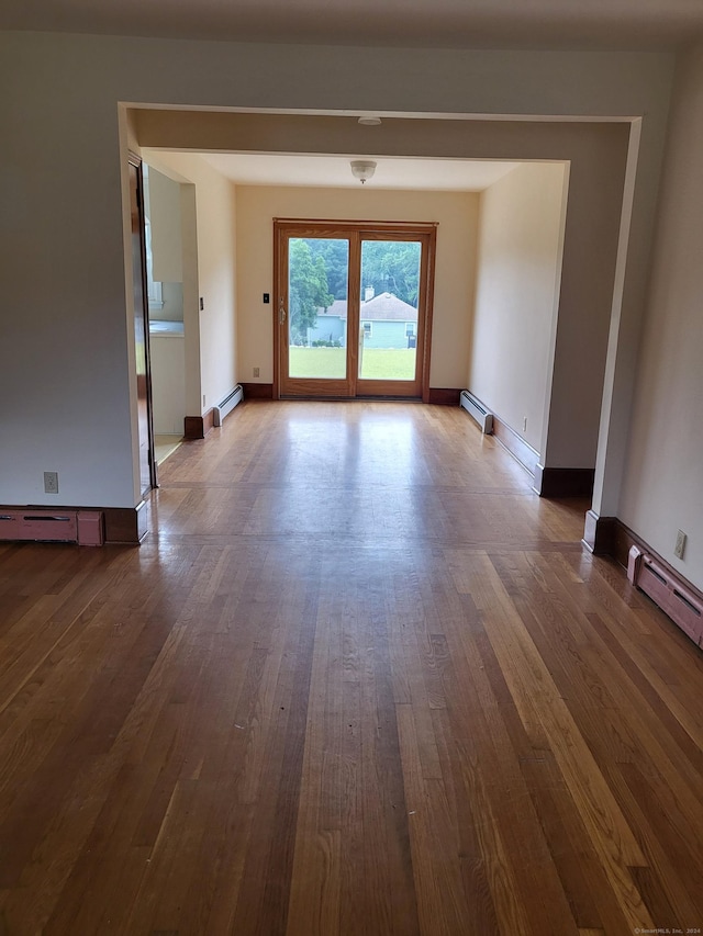 spare room with hardwood / wood-style floors and a baseboard radiator