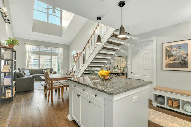 kitchen featuring white cabinetry, decorative light fixtures, dark hardwood / wood-style floors, and dark stone countertops