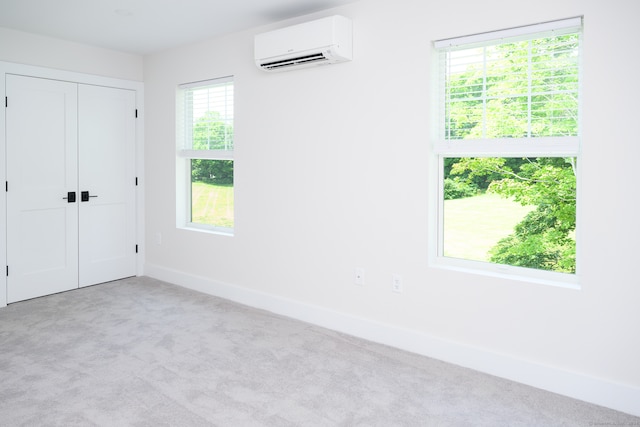 unfurnished bedroom with light colored carpet, multiple windows, and a wall unit AC