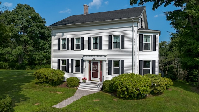 colonial house featuring a front lawn