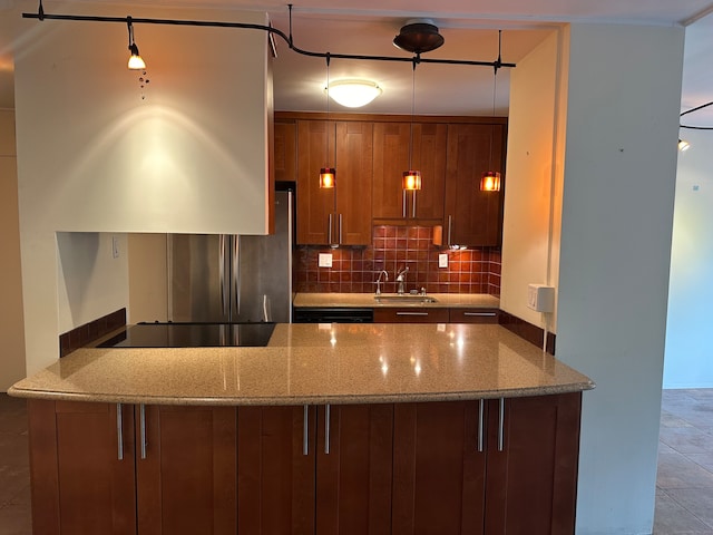 kitchen featuring light tile patterned floors, backsplash, light stone countertops, stainless steel fridge, and sink