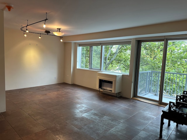 unfurnished living room featuring dark tile patterned flooring and track lighting