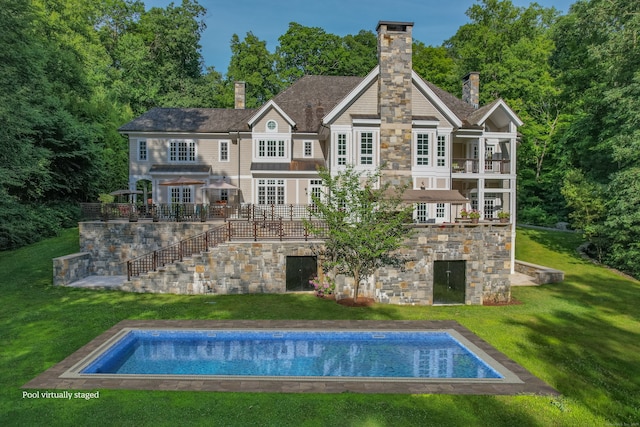 rear view of property featuring a patio, a lawn, and a balcony