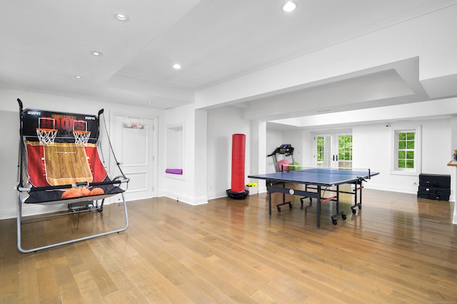 rec room featuring french doors, hardwood / wood-style floors, and a raised ceiling