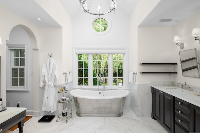 bathroom featuring vanity, a notable chandelier, and a bathing tub