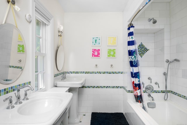 bathroom featuring tile walls, tile patterned floors, shower / bath combo with shower curtain, and sink