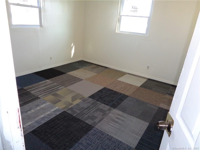 spare room featuring dark colored carpet