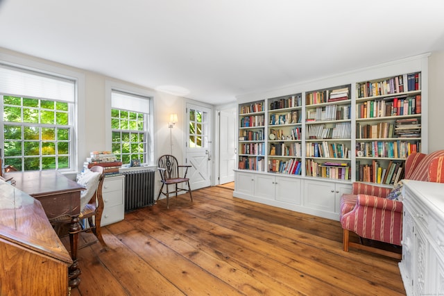 living area with wood-type flooring and radiator heating unit