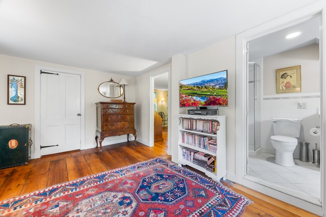 living area with tile walls and hardwood / wood-style floors