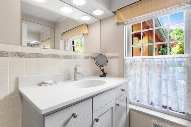 bathroom with vanity, backsplash, and tile walls