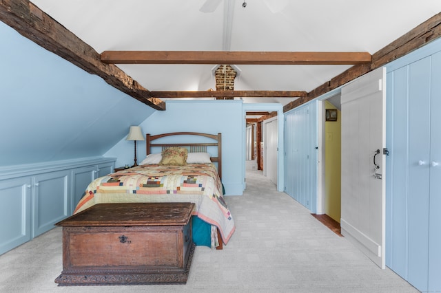 bedroom featuring light carpet, vaulted ceiling with beams, and ceiling fan