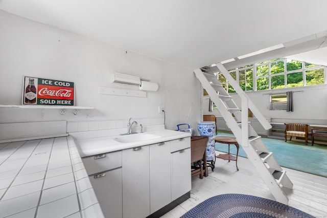 kitchen with white cabinets, sink, and light tile patterned floors