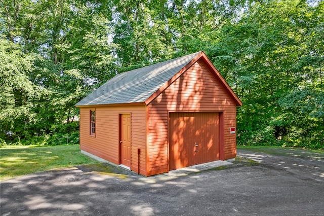 view of outbuilding featuring a yard and a garage