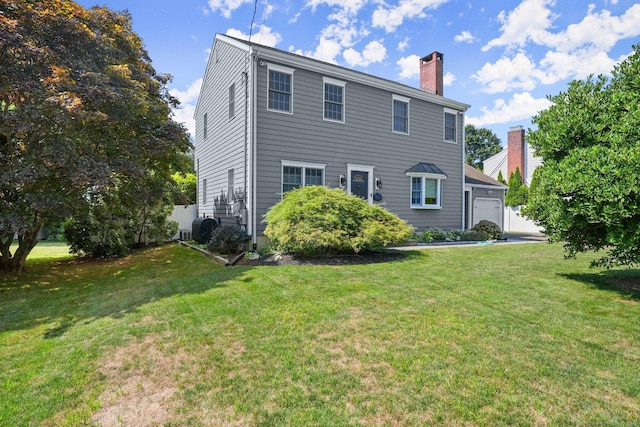 back of house with a yard and a garage