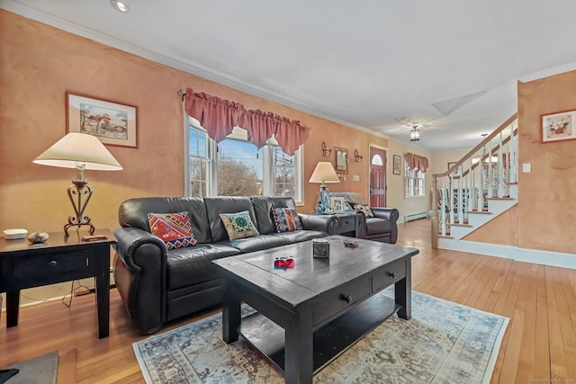 living room featuring baseboard heating, hardwood / wood-style floors, and ornamental molding