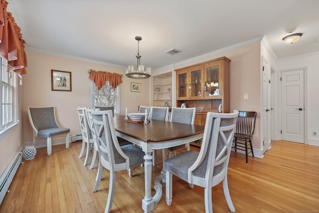 dining area featuring an inviting chandelier, crown molding, light hardwood / wood-style flooring, and a baseboard heating unit