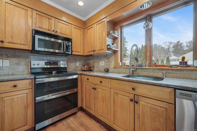 kitchen with tasteful backsplash, light stone countertops, sink, and appliances with stainless steel finishes