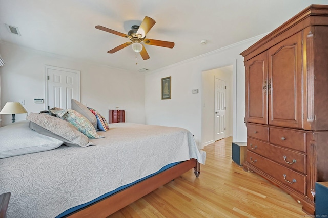 bedroom with ceiling fan, crown molding, and light hardwood / wood-style flooring