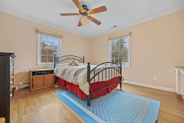 bedroom with ceiling fan, light wood-type flooring, baseboard heating, and multiple windows