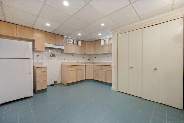 kitchen with a paneled ceiling, sink, light brown cabinets, and white refrigerator