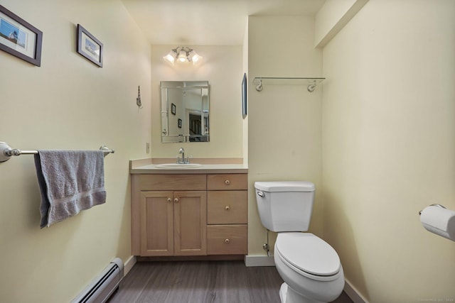 bathroom featuring hardwood / wood-style floors, vanity, toilet, and baseboard heating