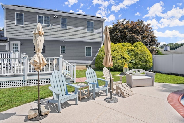 back of property with a patio, a wooden deck, and a lawn