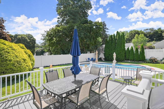 wooden deck featuring a lawn and a fenced in pool