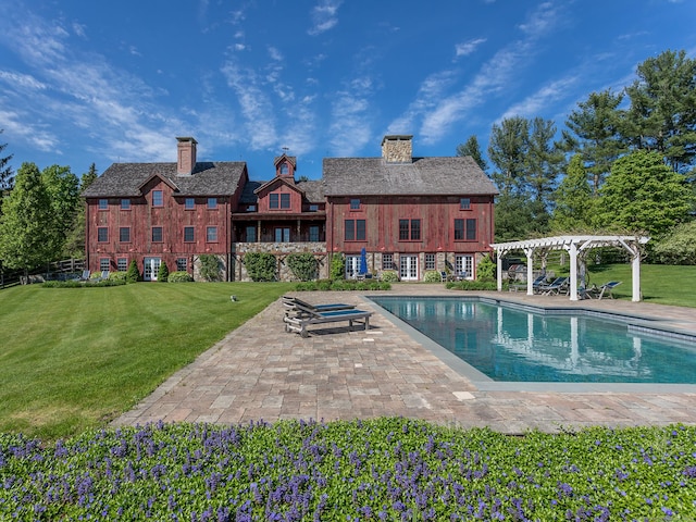 pool with a lawn, a patio area, and a pergola