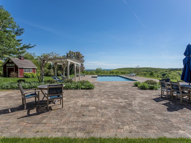 view of swimming pool featuring an outdoor structure, a patio area, and a pergola