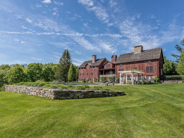 back of property with a yard and a chimney