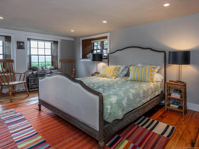 bedroom with wood finished floors, baseboards, and recessed lighting