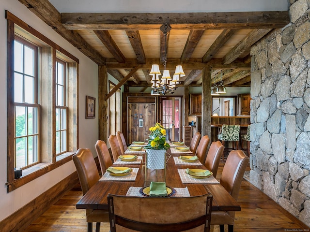 dining space featuring hardwood / wood-style flooring, a notable chandelier, wood ceiling, a healthy amount of sunlight, and beam ceiling